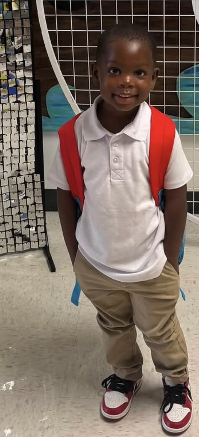 Child smiling with a red backpack