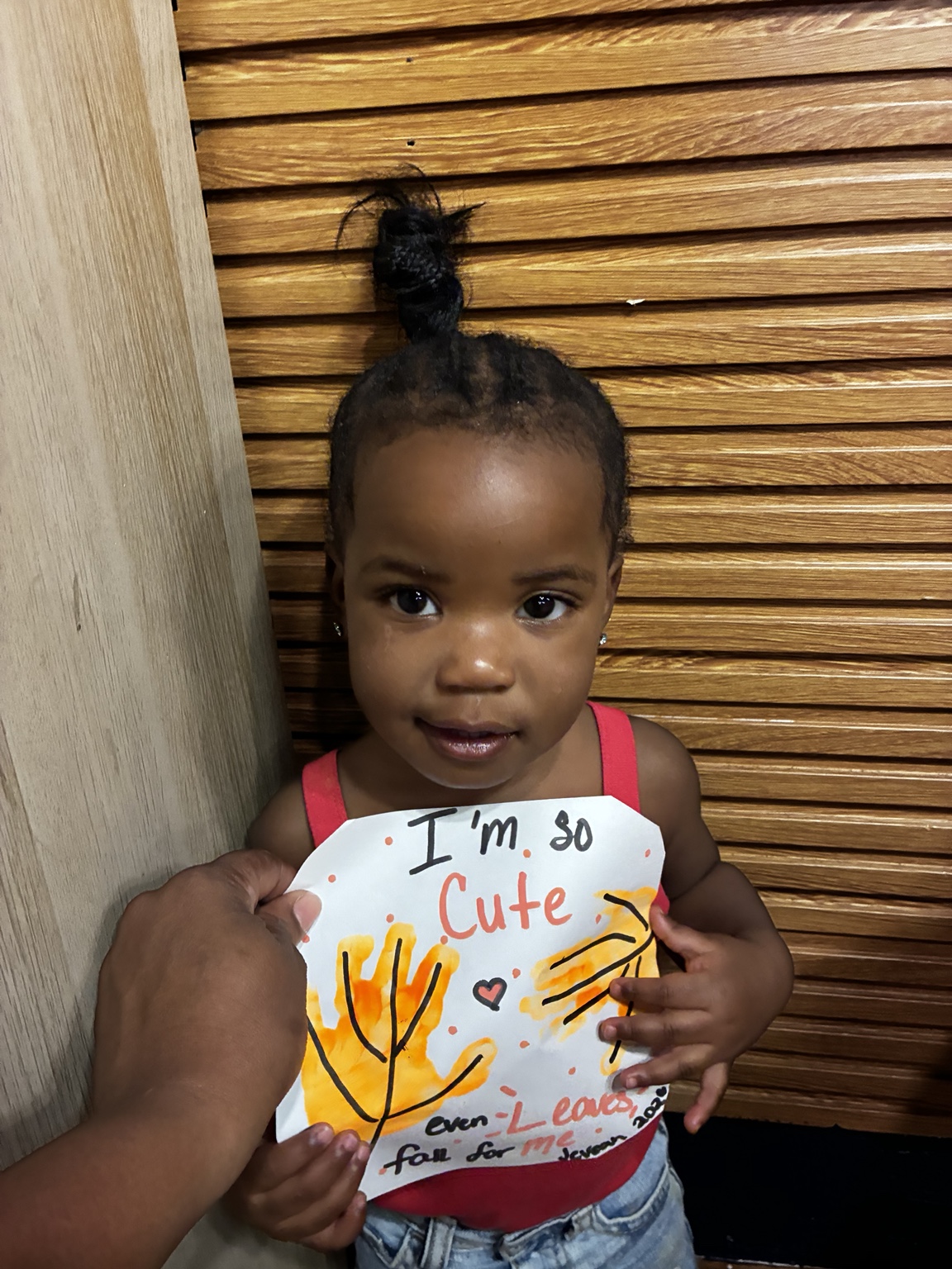 Child holding an autumn handprint craft